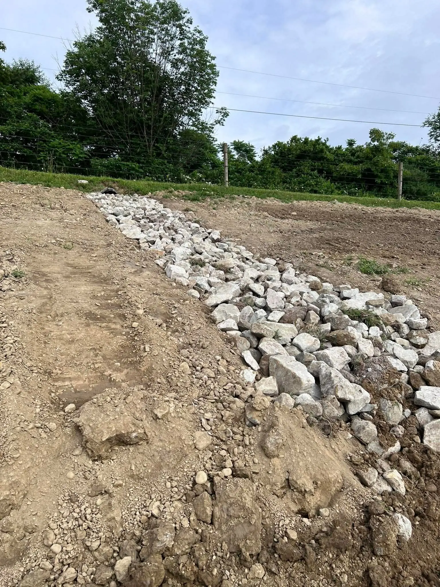 Engineered rock drainage swale built into a residential lot by Poole Dirt Work
